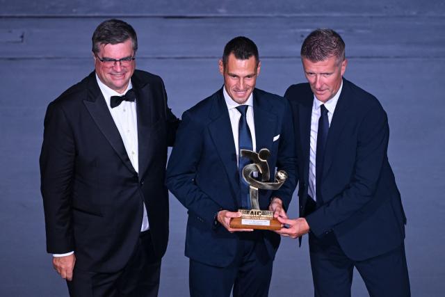 Italian Referee Maurizio Mariani (C) poses after receiving the best referee of the year award next to Andrea Battista (L) and referee Daniele Orsato (R) during the Italian Footballers' Association (AIC) gala and awards ceremony at La Scala Theatre in Milan, Italy on September 2, 2026. (Photo by Piero CRUCIATTI / AFP)