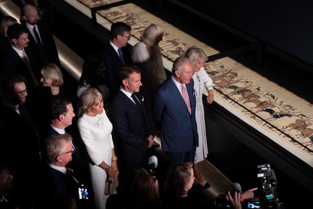 Britain's King Charles III (2R) and Britain's Queen Camilla (R) alongside France's President Emmanuel Macron (C) and his wife Brigitte Macron (3L) and British Museum Chairman George Osborne (2L) view sections of the Bayeux Tapestry during a preview event for the Bayeux Tapestry Exhibition, at the British Museum in London on September 2, 2026. (Photo by Jeanne Accorsini / POOL / AFP)