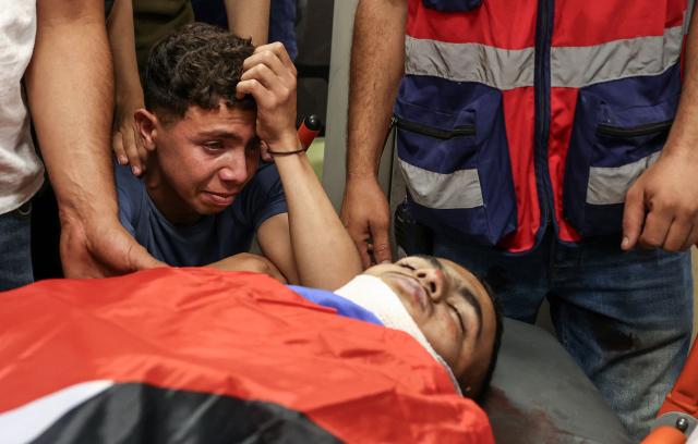 Relatives of Khalil Rasem Khalil Shehadeh mourn over his body during  the funeral of two Palestinians killed in Al-Mughayyir, east of Ramallah, following an Israeli settler attack and subsequent Israeli army raid, at the Ramallah Government Hospital in the occupied West Bank on September 2, 2026. Violence by Israeli settlers towards Palestinians in the West Bank has persisted for years, often with little or no legal consequence, but recent months have seen a surge in attacks. More than 500,000 Israelis live in settlements in the Palestinian territory, which are illegal under international law, among some three million Palestinians. Israel has occupied the West Bank since 1967. (Photo by Zain JAAFAR / AFP)