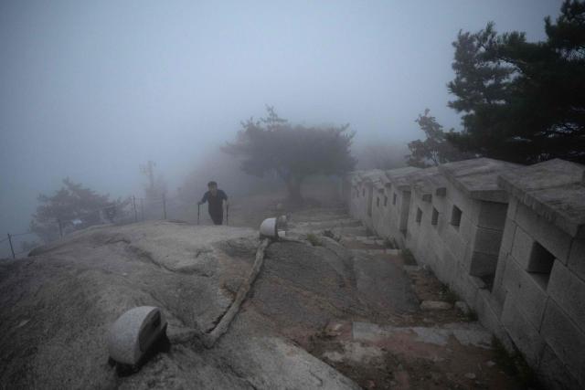 A hiker navigates morning fog on the summit of Inwangsan Mountain in Seoul on September 3, 2026. (Photo by Lillian SUWANRUMPHA / AFP)