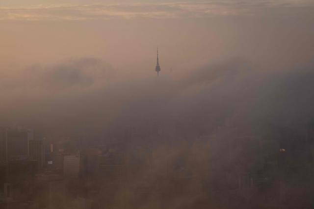 The top of Namsan Seoul Tower is seen behind morning fog in Seoul on September 3, 2026. (Photo by Lillian SUWANRUMPHA / AFP)