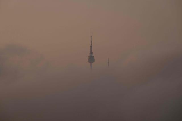The top of Namsan Seoul Tower is seen behind morning fog in Seoul on September 3, 2026. (Photo by Lillian SUWANRUMPHA / AFP)
