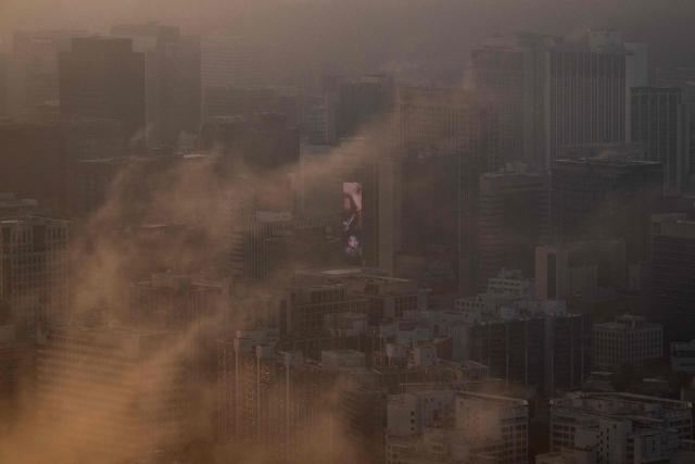An advertisement for cosmetics is seen on a building behind morning fog in Seoul on September 3, 2026. (Photo by Lillian SUWANRUMPHA / AFP)
