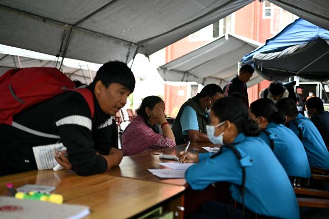 Family members register their information with police personnel to give blood samples for DNA testing to help identify their missing relatives after flash floods, at the Nepal Police Hospital in Kathmandu on September 3, 2026. Nepali families were holding symbolic funeral ceremonies to "liberate the souls" of loved ones missing since deadly flash floods swept away their villages and homes in the Himalayan region a week ago. (Photo by Manan VATSYAYANA / AFP)