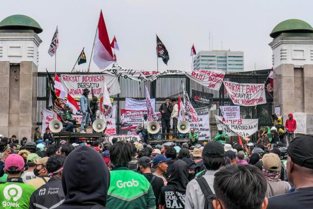 (FILES) Protesters deliver speeches and put up posters and banners on a gate during a demonstration urging lawmakers to immediately pass an asset forfeiture law for corruptors outside the Parliament building in Jakarta on August 27, 2026. Disinformation about ongoing anti-government protests in Indonesia has inundated social media in what investigators say is a coordinated attempt to spread propaganda about the one-year-old movement. (Photo by AZWAR IPANK / AFP)