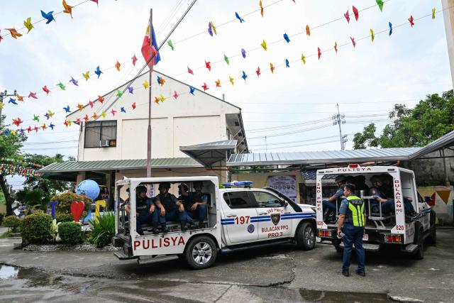 Policemen standby after a nationwide school drills to safeguard students from armed intruders, at a school in San Rafael, Bulacan on September 3, 2026. The drills came following a student livestreaming himself shooting another schoolmate dead before taking his own life at a high school in the Philippines on August 18, authorities said. (Photo by Jam STA ROSA / AFP)