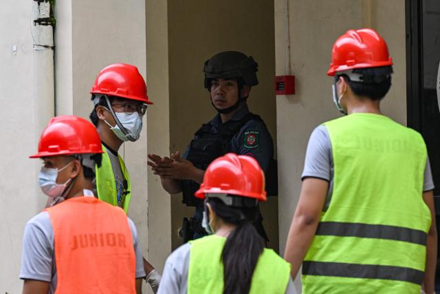 A policeman and rescuers gather during a nationwide school drills to safeguard students from armed intruders, at a school in San Rafael, Bulacan on September 3, 2026. The drills came following a student livestreaming himself shooting another schoolmate dead before taking his own life at a high school in the Philippines on August 18, authorities said. (Photo by Jam STA ROSA / AFP)