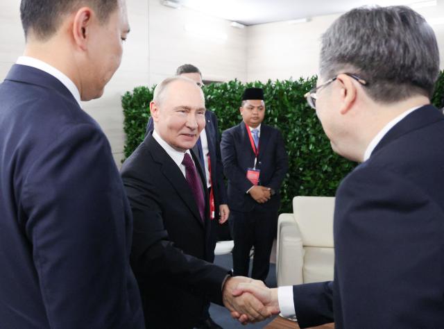 In this pool photograph distributed by the Russian state agency Sputnik, Russia's President Vladimir Putin greets Chinese Vice Premier Ding Xuexiang during the Eastern Economic Forum in Vladivostok on September 3, 2026. (Photo by Vyacheslav PROKOFYEV / POOL / AFP)