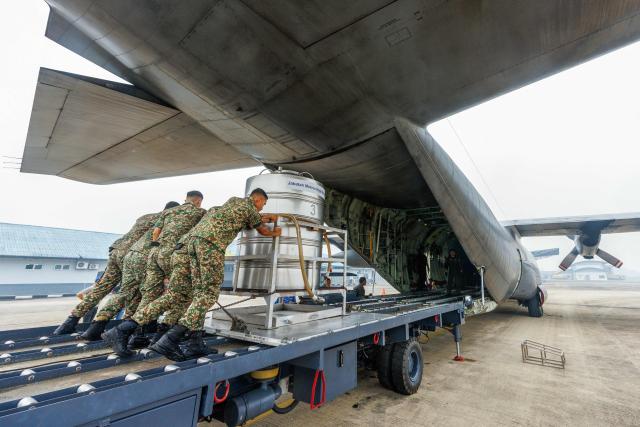Members of the Royal Malaysian Air Force push a cloud-seeding tank into a C-130 aircraft at the air force base in Kuching, the capital of Sarawak state on the island of Borneo, on September 3, 2026. Malaysia launched a three-day cloud-seeding operation on September 3 in a bid to ease hazardous haze choking Sarawak state, as smoke from Indonesian forest fires pushed air quality to dangerous levels. (Photo by AFP) / Malaysia OUT