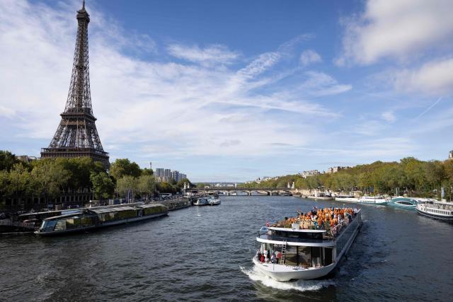 Members of the Bochasanwasi Akshar Purushottam Swaminarayan Sanstha (BAPS) Hindu community pass the Eiffel tower as they take part in a ceremonial river parade on the river Seine in Paris on September 3, 2026, as part of a series of religious celebrations and rituals. (Photo by Kenzo TRIBOUILLARD / AFP)