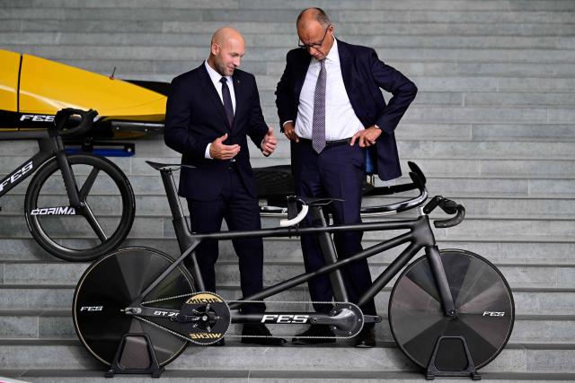 German Chancellor Friedrich Merz (R) and Germany's newly appointed Minster of Sport Ronald Rauhe look at a tandem racing bike during his presentation at the Chancellery in Berlin on September 3, 2026. (Photo by John MACDOUGALL / AFP)