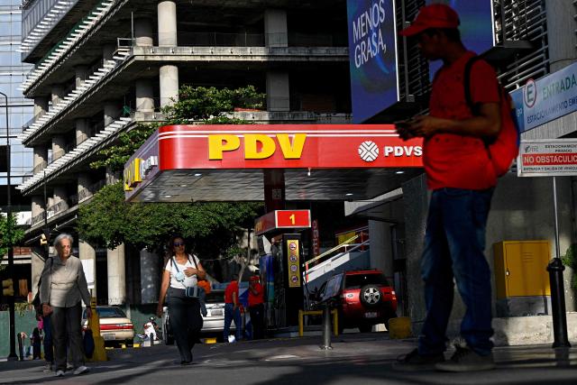 People walk past a PDVSA gas station in Caracas on September 3, 2026. (Photo by Federico PARRA / AFP)