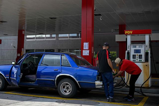 A worker refuels a car at a gas station in Caracas on September 3, 2026. (Photo by Federico PARRA / AFP)