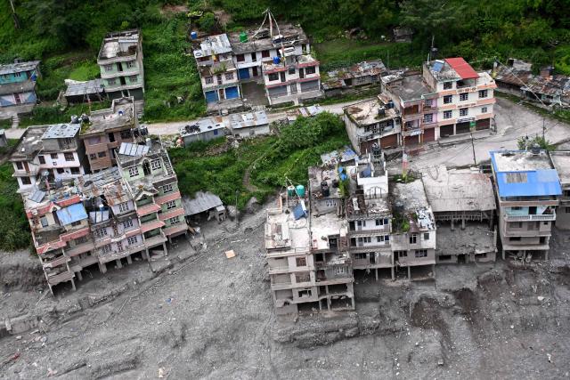 An aerial view shows houses damaged and deluged in sludge in the aftermath of flash floods at Syabrubesi in Nepal's Rasuwa district on September 3, 2026. More than 1,200 people have been killed and nearly 5,000 are missing on both sides of the China-Nepal border since the catastrophic glacial mountain collapse on August 26, according to tolls by both nations on September 3. (Photo by Prakash MATHEMA / AFP)