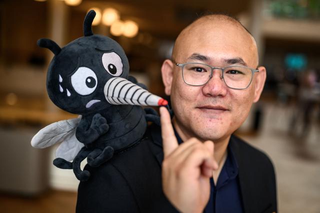 Canadian Associate Professor Changhong Cao poses with a fake moskito ahead of the 2026 Ig Nobel Prize Ceremony in Zurich, on September 3, 2026. Changhong Cao was awarded with his team the Ig Nobel Prize in technology for pioneering the use of mosquito proboscises as high-resolution 3D printing nozzles, a process called Necroprinting. The Ig Nobel Prize is a parody of the Nobel Prize, awarded every autumn to celebrate ten unusual or trivial achievements in scientific research. (Photo by Fabrice COFFRINI / AFP)
