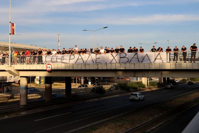 A group of people gathered on a footbridge over a motorway hold a banner reading "Thank you general" as they greet a convoy carrying the body of Bosnian Serb war criminal Ratko Mladic as it passes through Belgrade, Serbia, on September 3, 2026. Mladic's body arrived in Serbia earlier in the day and was driven from the airport under police escort after being received with military honours. Mladic died the previous week while serving a life sentence for genocide, war crimes and crimes against humanity committed during the 1992-1995 Bosnian war. (Photo by Pedja MILOSAVLJEVIC / AFP)