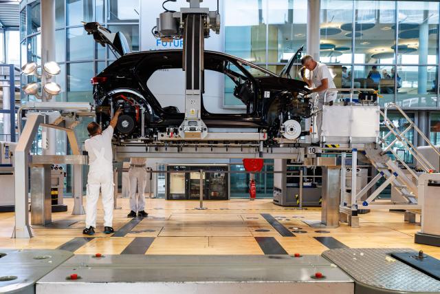 (FILES) Employees work on the assembly line for the Volkswagen (VW) ID.3 electric car of German carmaker Volkswagen, at the 'Transparent Factory' (Glaeserne Manufaktur) production site of German carmaker Volkswagen (VW) in Dresden, eastern Germany, on May 14, 2025. German car giant Volkswagen said on September 3, 2026 that management and unions had agreed to cut a further 50,000 jobs by the end of the decade, bringing total job losses to 100,000. "It is essential to systematically align workforce levels with economic realities," the 10-brand group said in a statement, adding the firm had approved a plan which involved "the reduction of around 50,000 jobs" on top of the 50,000 already agreed. (Photo by JENS SCHLUETER / AFP)