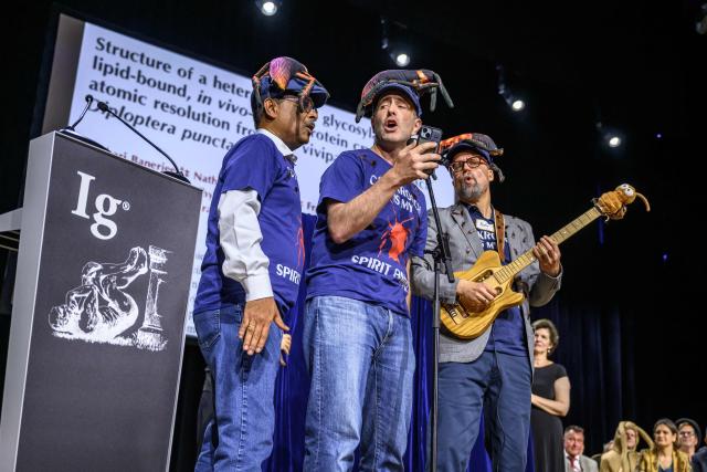 (From L) Professors Subramanian Ramaswamy, Leonard Chavas, and doctor Nathan Coussens sing after being awarded during the 2026 Ig Nobel Prize Ceremony in Zurich, on September 3, 2026. The team were awarded with the Ig Nobel Chemistry prize award for discovering that milk proteins from vivaparous cockroaches packs three times as much energy as milk proteins from cows. The Ig Nobel Prize is a parody of the Nobel Prize, which is awarded every autumn to celebrate ten unusual or trivial achievements in scientific research. (Photo by Fabrice COFFRINI / AFP)