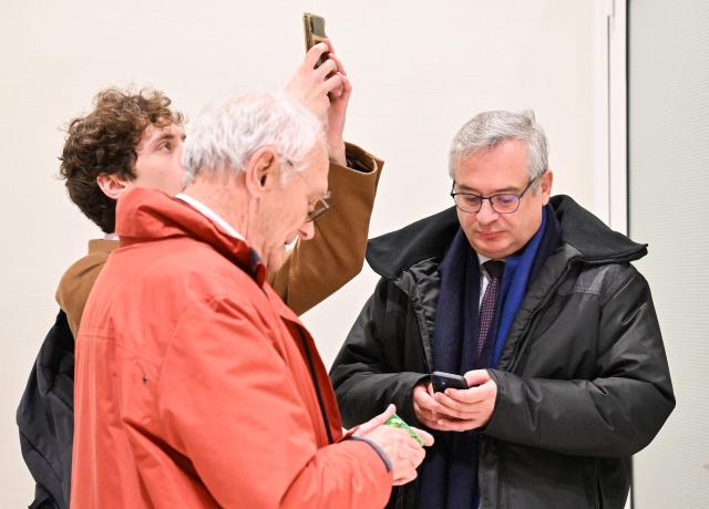 (FILES) France's Deputy Director of National Resources at the Ministry of the Interior and Overseas Pierre-Emmanuel Portheret (R) looks at his smartphone at the  Paris Judicial court, northern district of Paris on February 5, 2024, on the day of the decision of Paris court in his trial and ten other centrist executives and elected representatives, on charges of complicity in the misappropriation of public funds in a scandal over MoDem European parliamentary assistants. The appeal trial of François Bayrou along with ten other people, for alleged complicity in the misappropriation of public funds in a scandal over MoDem European parliamentary assistants will run from September 9 to October 5, 2026. (Photo by Miguel MEDINA / AFP)