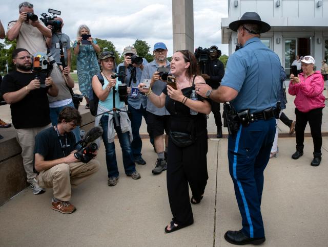 A woman is led away by a Massachusetts State Police Officer while protesting outside the courthouse as the jury deliberation phase continues in Lindsay Clancy's murder trial at the Plymouth County Superior Court in Plymouth, Massachusetts, on September 3, 2026. The defense for Lindsay Clancy, the US mother accused of murdering her three children, on Thursday accused a single holdout juror of blocking a verdict in the high-profile trial. Judge William Sullivan will hold an inquiry on Friday as jurors return for a seventh day of deliberations, after roughly 36 hours spent trying to reach a unanimous verdict. (Photo by Rick Friedman / AFP)