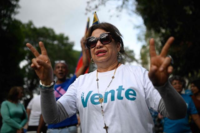 A supporter of Venezuelan opposition leader Maria Corina Machado makes a victory sign during a citizen assembly calling for presidential elections in the La Vega neighborhood of Caracas on September 3, 2026. Venezuelan opposition figure Maria Corina Machado on September 3 called for a democratic transition in her country after the interim government struck a massive oil deal with the United States. (Photo by Federico PARRA / AFP)
