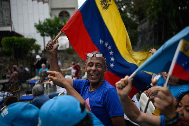 A supporter of Venezuelan opposition leader Maria Corina Machado waves a Venezuelan flag during a citizen assembly calling for presidential elections in the La Vega neighborhood of Caracas on September 3, 2026. Venezuelan opposition figure Maria Corina Machado on September 3 called for a democratic transition in her country after the interim government struck a massive oil deal with the United States. (Photo by Federico PARRA / AFP)
