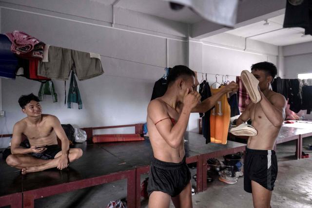 This photo taken on May 27, 2026 shows fighters using slip-on shoes as pads as they train in traditional Myanmar boxing known as Lethwei at a training camp in Hpa-an in Myanmar's Karen state. In a country consumed by conflict, a sport defined by brutality dominates: Myanmar's lethwei martial art, where headbutts are encouraged and knock-out blows are the aim of the game. (Photo by Sai Aung MAIN / AFP) / To go with AFP story Myanmar-conflict-lifestyle-box, FOCUS by Hla-Hla Htay and Joe Stenson