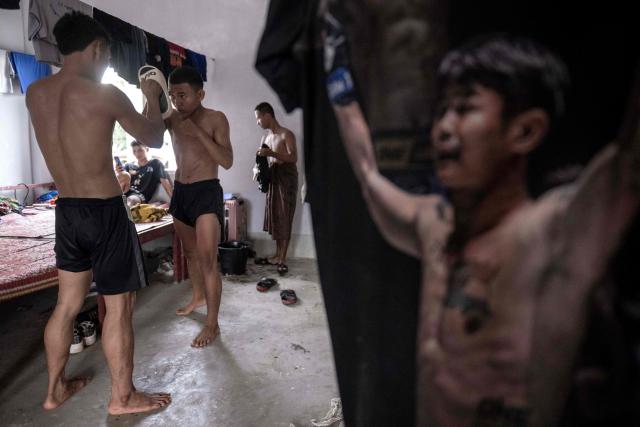 This photo taken on May 27, 2026 shows fighters using slip-on shoes as pads as they train in traditional Myanmar boxing known as Lethwei at a training camp in Hpa-an in Myanmar's Karen state. In a country consumed by conflict, a sport defined by brutality dominates: Myanmar's lethwei martial art, where headbutts are encouraged and knock-out blows are the aim of the game. (Photo by Sai Aung MAIN / AFP) / To go with AFP story Myanmar-conflict-lifestyle-box, FOCUS by Hla-Hla Htay and Joe Stenson