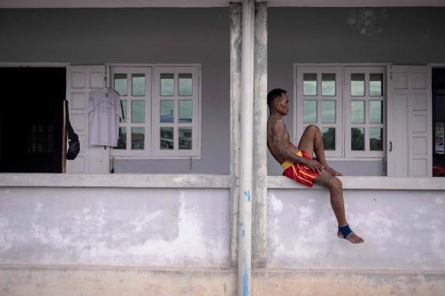 This photo taken on May 27, 2026 shows a coach resting after training fighters in traditional Myanmar boxing known as Lethwei at a training camp in Hpa-an in Myanmar's Karen state. In a country consumed by conflict, a sport defined by brutality dominates: Myanmar's lethwei martial art, where headbutts are encouraged and knock-out blows are the aim of the game. (Photo by Sai Aung MAIN / AFP) / To go with AFP story Myanmar-conflict-lifestyle-box, FOCUS by Hla-Hla Htay and Joe Stenson