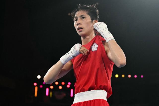 (FILES) Taiwan's Lin Yu-ting reacts after beating Poland's Julia Szeremeta (Blue) in the women's 57kg final boxing match during the Paris 2024 Olympic Games at the Roland-Garros Stadium, in Paris on August 10, 2024. Taiwanese boxer Lin Yu-ting told AFP she considered retiring after winning gold at the Paris Olympics but wanted to carry on fighting in part to defy those who questioned her eligibility. (Photo by Mauro PIMENTEL / AFP)