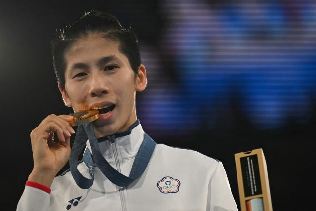 (FILES) Gold medallist Taiwan's Lin Yu-ting celebrates on the podium during the medal ceremony for the women's 57kg final boxing category during the Paris 2024 Olympic Games at the Roland-Garros Stadium, in Paris on August 10, 2024. Taiwanese boxer Lin Yu-ting told AFP she considered retiring after winning gold at the Paris Olympics but wanted to carry on fighting in part to defy those who questioned her eligibility. (Photo by Mauro PIMENTEL / AFP)