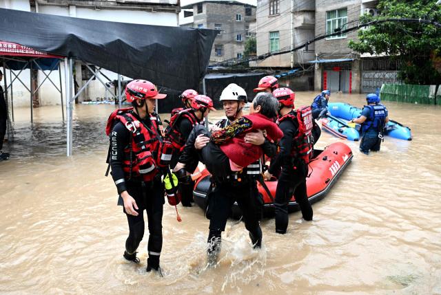 Members of a search and rescue team evacuate people affected by Typhoon Saudel in Minhou, Fuzhou, China's eastern Fujian province on September 3, 2026. (Photo by CNS / AFP) / China OUT