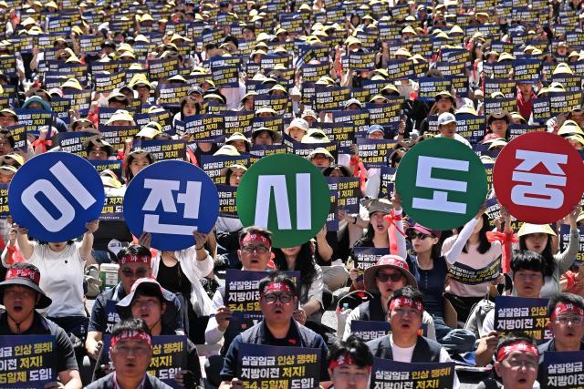 Members of the Korean Financial Industry Union hold signs during a strike rally to oppose the government’s plans to relocate financial institutions to the administrative city of Sejong, and demand improvements in working conditions, in Seoul on September 4, 2026. South Korea announced plans on September 3, to put a second presidential office and legislative complex in the administrative city of Sejong, as it accelerates efforts to move hundreds of institutions out of Seoul in a bid to lessen the capital's dominance. (Photo by Lillian SUWANRUMPHA / AFP)