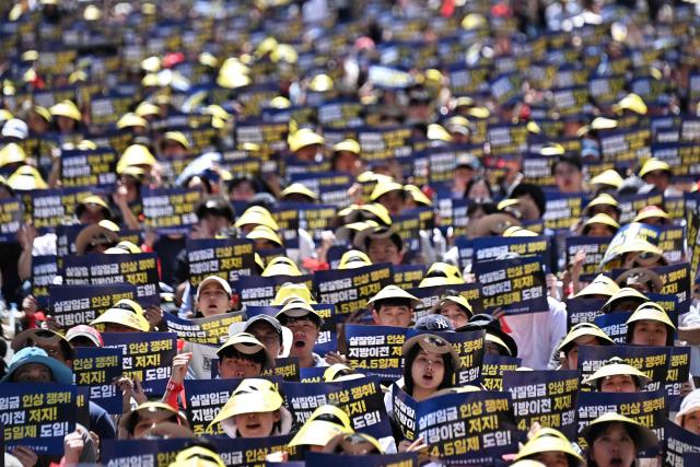 Members of the Korean Financial Industry Union hold signs during a strike rally to oppose the government’s plans to relocate financial institutions to the administrative city of Sejong, and demand improvements in working conditions, in Seoul on September 4, 2026. South Korea announced plans on September 3, to put a second presidential office and legislative complex in the administrative city of Sejong, as it accelerates efforts to move hundreds of institutions out of Seoul in a bid to lessen the capital's dominance. (Photo by Lillian SUWANRUMPHA / AFP)