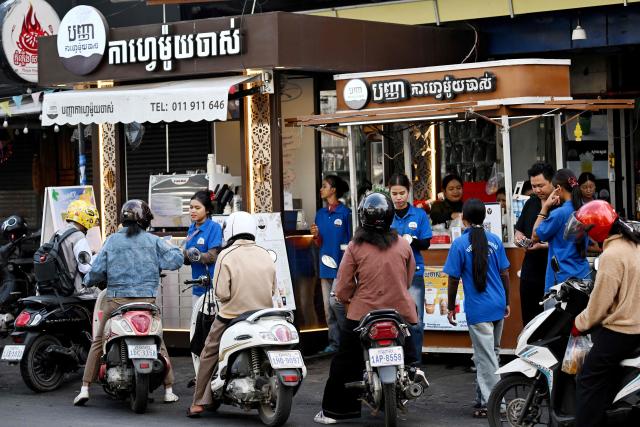 Workers pour hot water into coffee drip filters at a coffee stall in Phnom Penh on September 4, 2026. (Photo by TANG CHHIN Sothy / AFP)