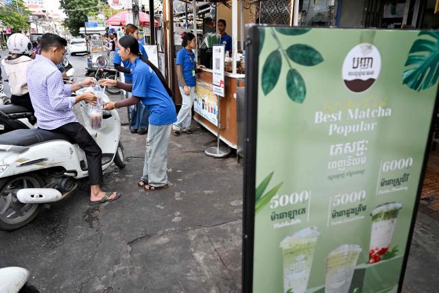 A man buys coffee in a plastic bag from a coffee stall in Phnom Penh on September 4, 2026. (Photo by TANG CHHIN Sothy / AFP)