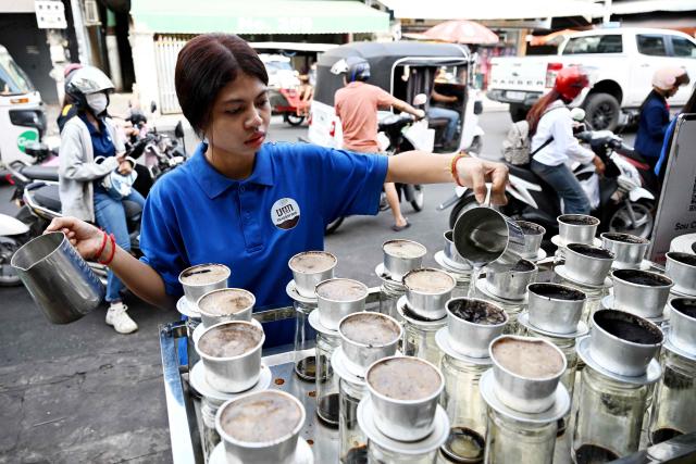 A worker pours hot water into coffee drip filters at a coffee stall in Phnom Penh on September 4, 2026. (Photo by TANG CHHIN Sothy / AFP)