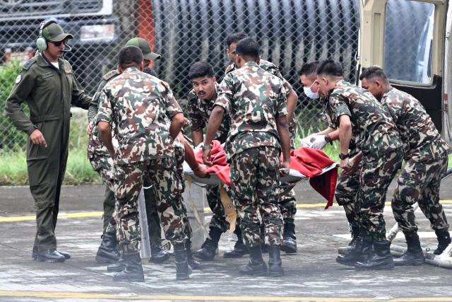 Army personnel disembark a helicopter carrying Kabir Maharjan, a worker who was trapped inside a tunnel of Trishuli-3A Hydropower Project, as they arrive at Chhauni Army Hospital in Kathmandu on September 4, 2026. Two hydropower workers were pulled from a tunnel buried by debris in Nepal on September 4, more than a week after catastrophic flooding swept through the area, government ministers said. (Photo by Arun SANKAR / AFP)