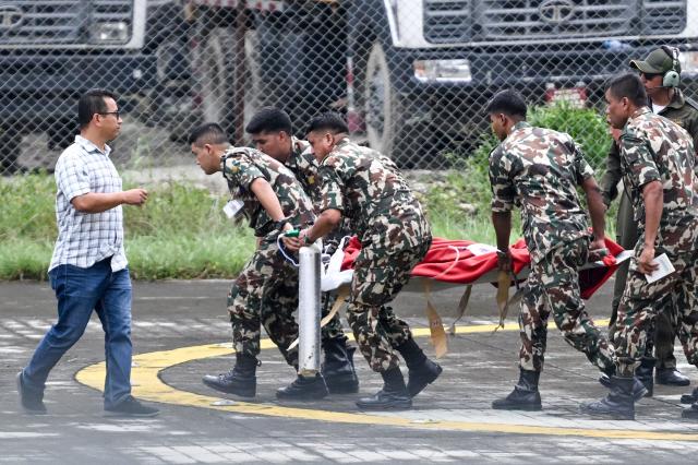 TOPSHOT - Army personnel disembark a helicopter carrying Kabir Maharjan, a worker who was trapped inside a tunnel of Trishuli-3A Hydropower Project, as they arrive at Chhauni Army Hospital in Kathmandu on September 4, 2026. Two hydropower workers were pulled from a tunnel buried by debris in Nepal on September 4, more than a week after catastrophic flooding swept through the area, government ministers said. (Photo by Arun SANKAR / AFP)