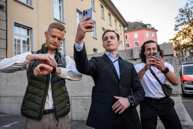 Leading figures of the Swiss far-right extremist group Junge Tat Tobias Lingg (L) and Manuel Corchia (C) arrive at Zurich District Court for their trail, in Zurich, on September 4, 2026. Six people from the far-right group Junge Tat appeared before the Zurich District Court, accused of hatred-related offenses, coercion, rioting, property damage and trespassing. The group's two main leaders face up to six months in prison. (Photo by Fabrice COFFRINI / AFP)