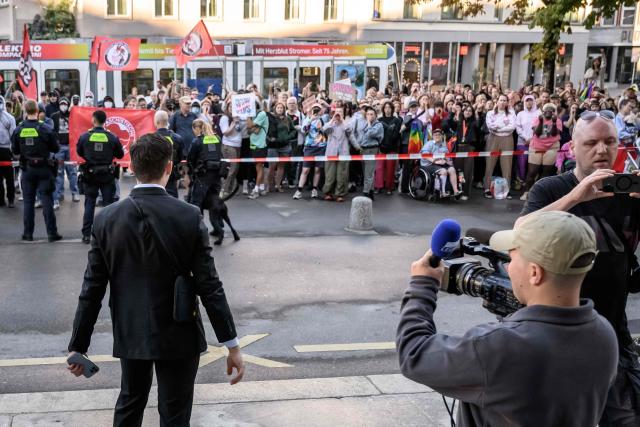 Manuel Corchia (L), a leading figure of the Swiss far-right group Junge Tat, faces LGBT and antifa protesters as he arrives at Zurich District Court for his trial, in Zurich, Switzerland, on September 4, 2026. Six people from the far-right group Junge Tat appeared before the Zurich District Court, accused of hatred-related offenses, coercion, rioting, property damage and trespassing. The group's two main leaders face up to six months in prison. (Photo by Fabrice COFFRINI / AFP)