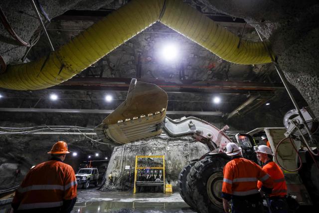 Workers talk as they stand near heavy machinery in a workshop located in the underground CSA Cobar copper mine, operated by Harmony Gold Mining company, located north of the New South Wales town of Cobar on September 4, 2026. (Photo by DAVID GRAY / AFP)