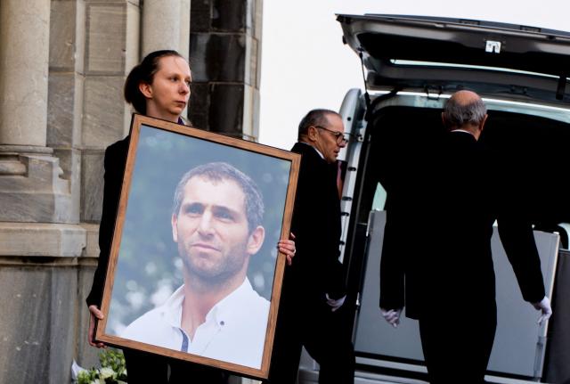 (FILES) A woman holds a portrait of Argentinian rugbyplayer Federico Martin Aramburu during his funeral in Biarritz, southwestern France, on March 26, 2022. Two ultra-right-wing activists, Loik Le Priol, 32, and Romain Bouvier, 35, will go on trial on September 7, 2026, in front of the Assize Court, France's criminal court, over the deadly shooting of former Argentine rugby international Federico Martin Aramburu following in March 2022 in Paris. (Photo by Thibault SOUNY / AFP)