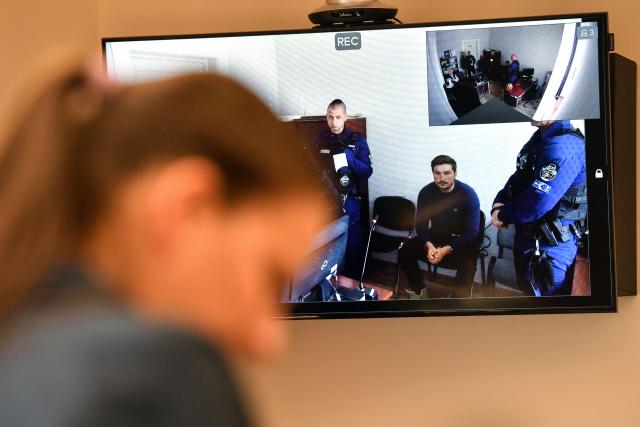 (FILES) Loik Le Priol (2ndR), main suspect in the deadly shooting of former star Argentine rugby player Federico Martin Aramburu in Paris, is seen on a screen inside the Budapest Metropolitan Court on March 25, 2022, as he arrives for his virtual hearing at the Zahony police station, as a translator stands in front of the screen. Two ultra-right-wing activists, Loik Le Priol, 32, and Romain Bouvier, 35, will go on trial on September 7, 2026, in front of the Assize Court, France's criminal court, over the deadly shooting of former Argentine rugby international Federico Martin Aramburu following in March 2022 in Paris. (Photo by GERGELY BESENYEI / AFP)