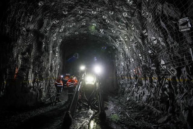 Workers and officials check the development drive created by a multi-purpose rock drilling machine known as a ‘jumbo’ in the underground CSA Cobar copper mine, operated by Harmony Gold Mining company, located north of the New South Wales town of Cobar on September 4, 2026. (Photo by DAVID GRAY / AFP)
