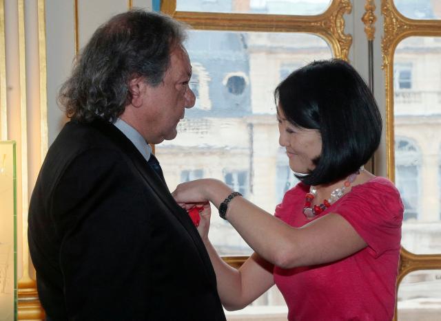 (FILES) French Minister of Culture and Communication Fleur Pellerin (R) presents Film director and actor Tony Gatlif  with the Lйgion d’honneur in Paris on March 30, 2015. Filmmaker Tony Gatlif, a champion of Romani culture with some 20 films to his credit, including “Gadjo Dilo,” died at the age of 77, his family told AFP on September 4, 2026. (Photo by JACQUES DEMARTHON / AFP)