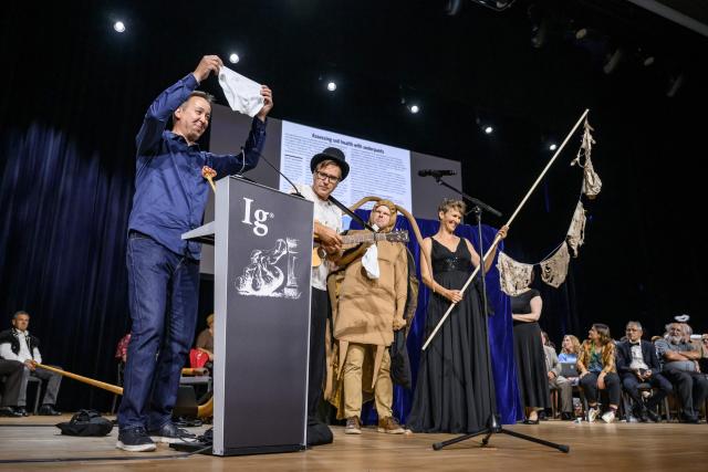 Ig Nobel Soil Science prize winners (From L) Marcel van der Heijden, Franz Bender, Atlant Bieri and Pia Viviani reacts on stage during the award ceremony in Zurich, on September 3, 2026. The team were awarded "for burying 1000 identical pairs of underpants in more than 25 countries, and then digging them up after two months". The Ig Nobel Prize is a parody of the Nobel Prize, which is awarded every autumn to celebrate ten unusual or trivial achievements in scientific research. (Photo by Fabrice COFFRINI / AFP)