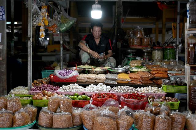 A man uses his phone while waiting for customers at his shop in Nha Trang, Vietnam's Khanh Hoa Province on September 4, 2026. (Photo by Nhac NGUYEN / AFP)