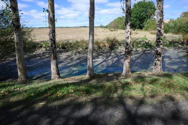 This picture shows a dry water stream in Machecoul, western France, on September 3, 2026. After a summer marked by record-breaking heat waves, wildfires, and drought, the government announced on September 4, 2026 one billion euros in emergency aid to support France’s hard-hit agricultural sector. (Photo by Loic VENANCE / AFP)