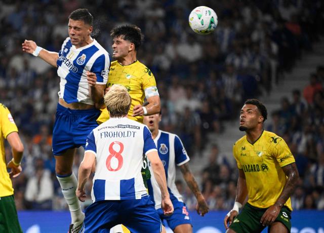 FC Porto's Polish defender #05 Jan Bednarek (L) scores an equalizing goal as he wins a header against Moreirense's Portuguese defender #76 Dinis Pinto during the Portuguese league football match between FC Porto and Moreirense FC at Dragao stadium in Porto on September 4, 2026. (Photo by Miguel RIOPA / AFP)